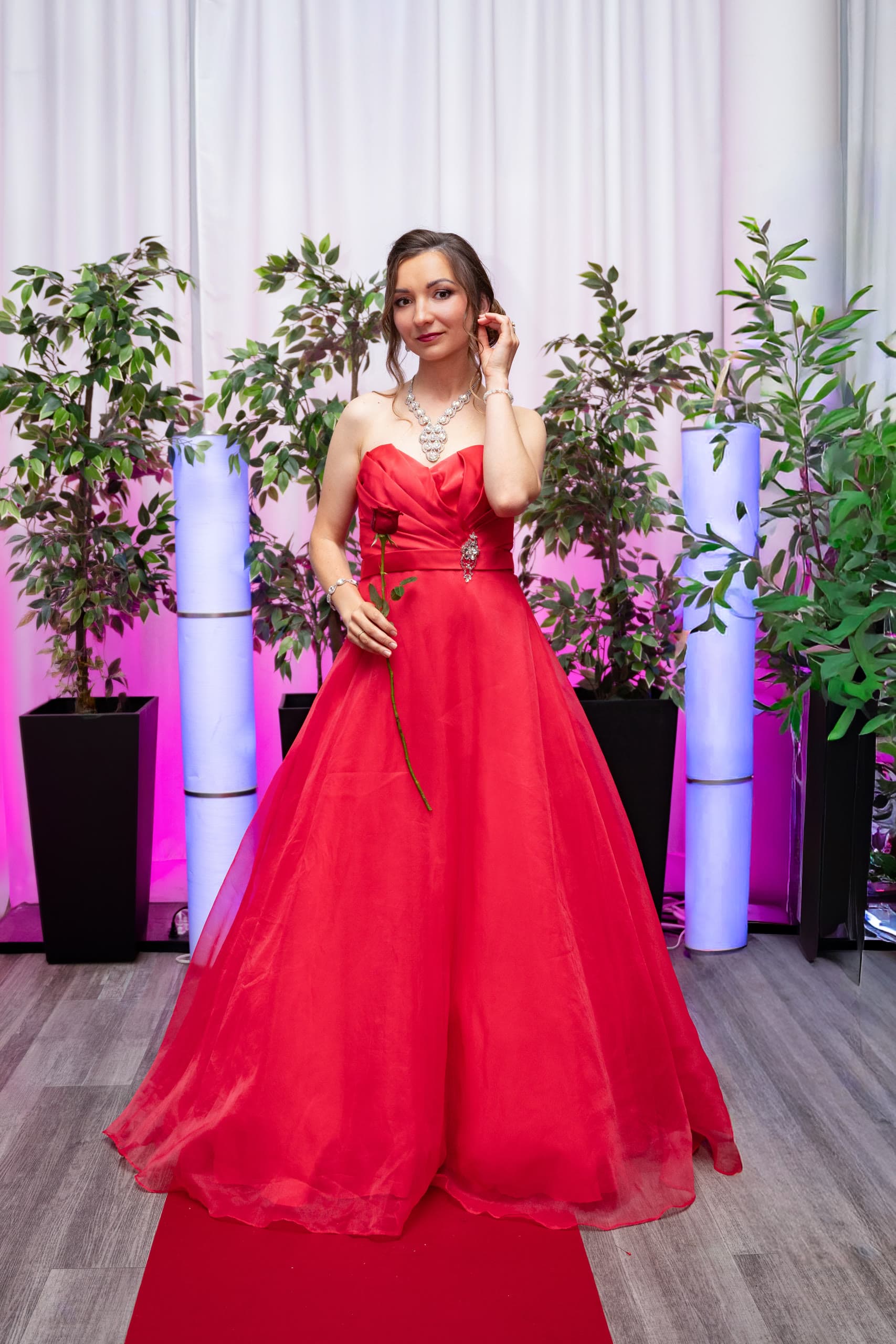 Anastasiia standing in a flowing red gown