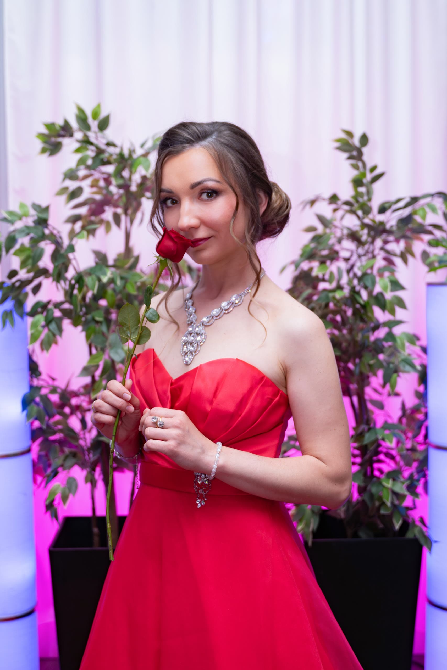 Anastasiia smiling with a red rose